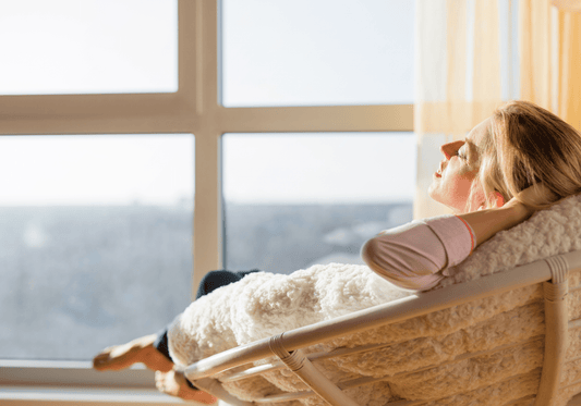 Young woman sitting in a cozy room, looking thoughtful and hopeful, symbolizing the emotional journey of navigating premature ovarian insufficiency and diminished ovarian reserve